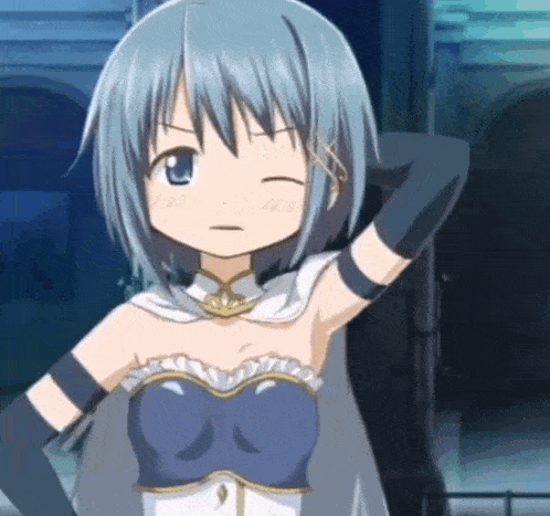 a girl with blue hair and black gloves is standing in front of a building and making a funny face .