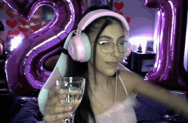 a woman wearing headphones is holding a glass of wine
