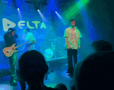a group of people on stage with a delta sign behind them