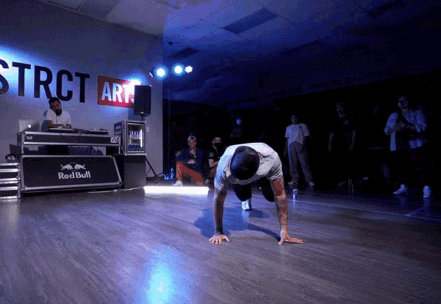 a man dancing in front of a sign that says red bull