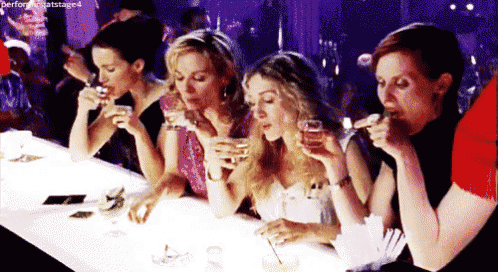 a group of women are sitting at a table drinking champagne .