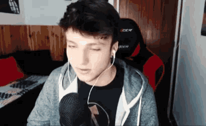 a young man is sitting in front of a microphone wearing headphones .
