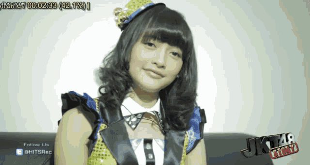 a girl is sitting on a couch in front of a screen that says jkt48 story