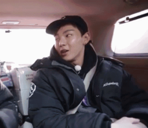a man wearing a hat and a jacket is sitting in a car