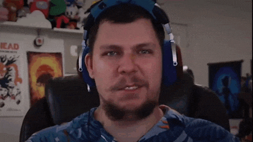 a man with a beard is wearing headphones and a blue shirt .