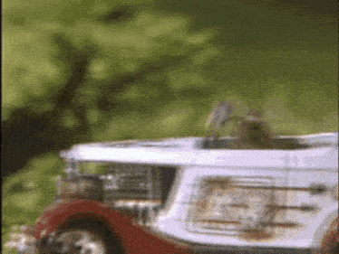 a red and white toy car with a clock on the back