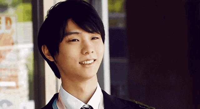 a man in a suit and tie is smiling and looking at the camera .