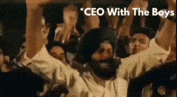 a man with a beard is standing in front of a crowd of people with their hands in the air .