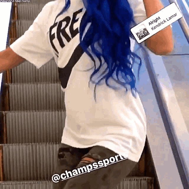 a woman with blue hair and a white shirt that says free on it
