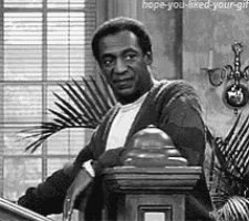 a black and white photo of a man standing at a podium with a palm tree in the background .