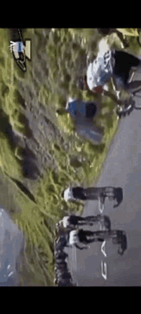 a group of people are riding bicycles down a road with the letter v on the bottom