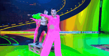a group of people are dancing on a stage in neon pink pants .