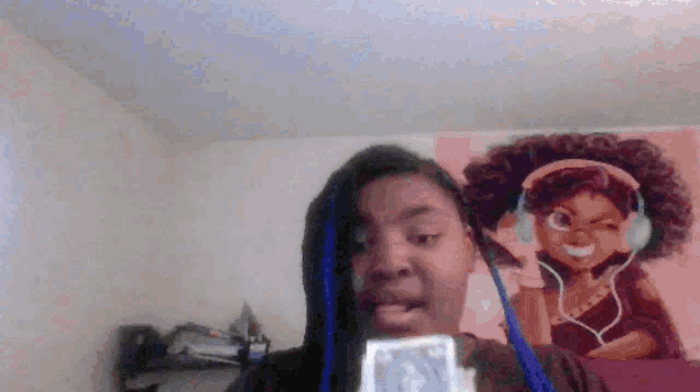 a girl wearing headphones is holding a card in front of a picture of a girl with afro hair