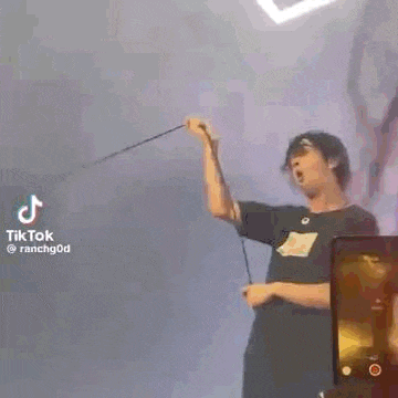 a man is singing into a microphone while holding a rope .