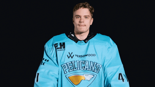 a man wearing a blue pelican 's jersey holds his hands up