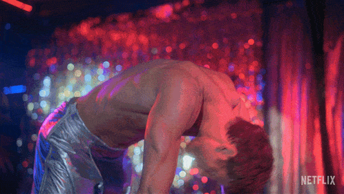 a man without a shirt is dancing in front of a curtain that says netflix on it
