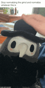 a stuffed animal wearing a top hat is being propped up by a person