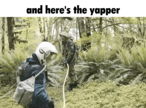 a man in a helmet is standing in the woods with a rope around his neck .