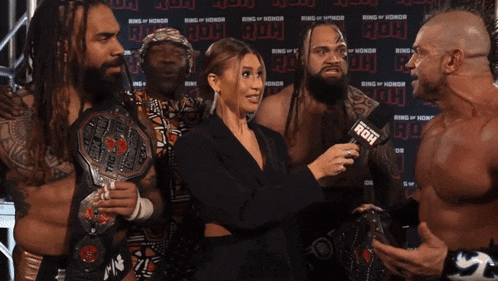 a group of wrestlers are being interviewed by a woman with the words we 're in the money above them