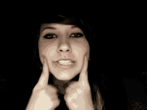 a woman is making a funny face while holding her face with her hands .