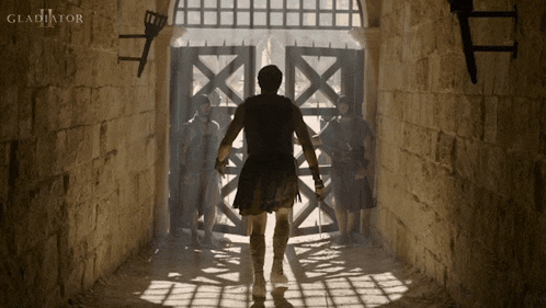 a movie poster for gladiator shows a man walking through a doorway