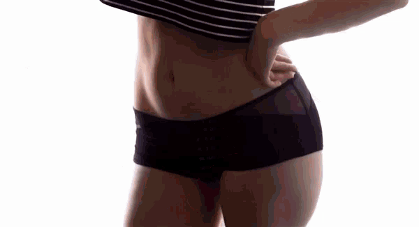 a woman is wearing a black and white striped crop top with the word weirds written on it .