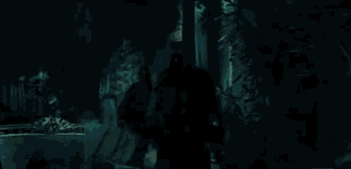 a silhouette of a person standing in a dark room with a stained glass window .