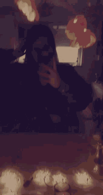 a woman taking a selfie in front of a mirror with glasses on the table