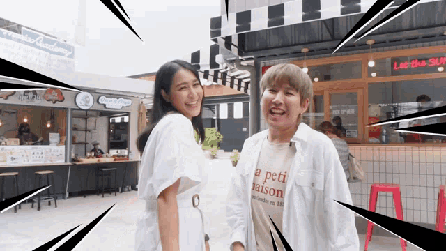 a woman wearing a white shirt that says a peti maison