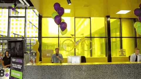 a man stands at a counter in front of a sign that says 80