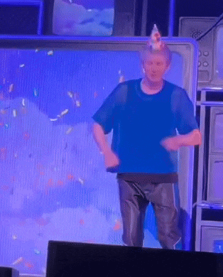a man wearing a birthday hat is dancing on a television