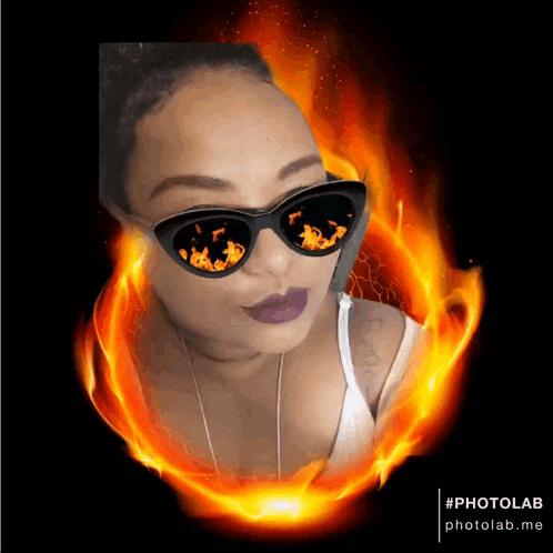 a woman wearing sunglasses with flames reflected in the lenses
