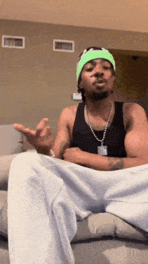 a man wearing a green headband and a black tank top