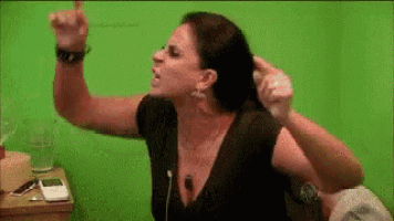a woman in a black dress is standing in front of a green wall