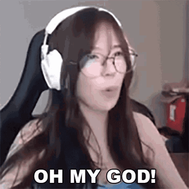 a woman wearing headphones and glasses is sitting in a chair and making a funny face .