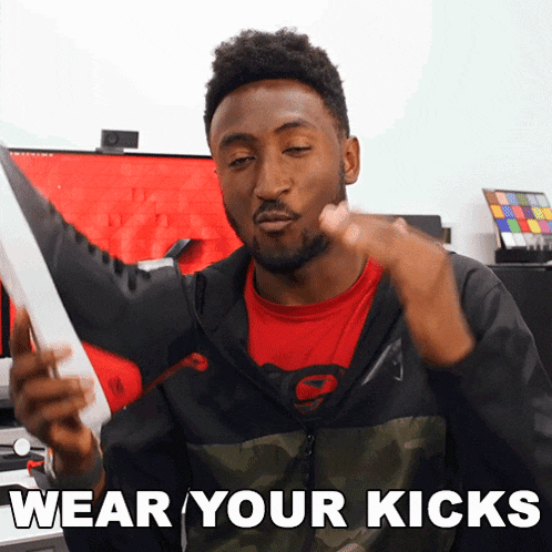 a man wearing a red shirt and a black jacket says " wear your kicks "