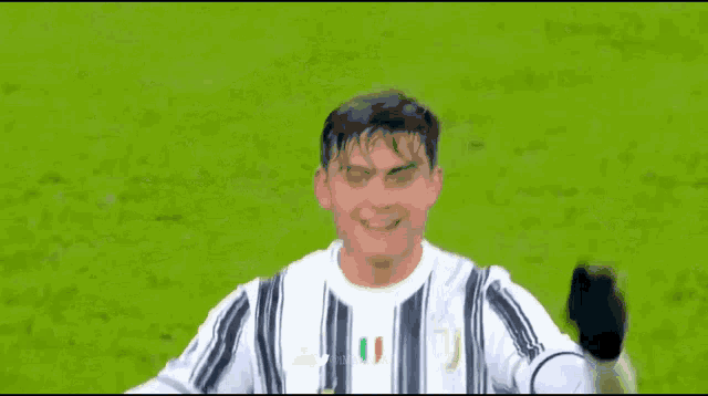 a soccer player wearing a jeep shirt is smiling on the field