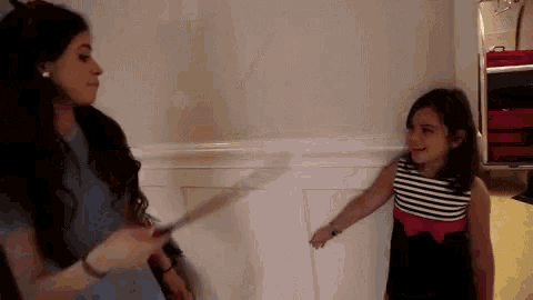 a woman and a little girl are standing next to each other in a room