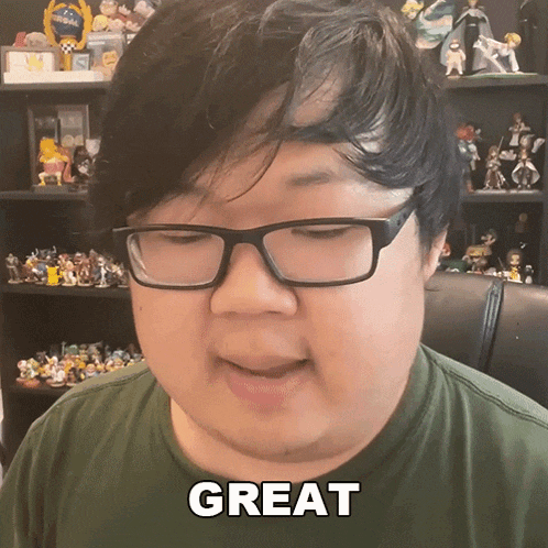 a man wearing glasses says great in front of a shelf full of figurines