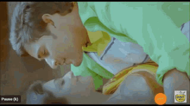 a video of a man and woman kissing with a pause ( k ) button in the corner