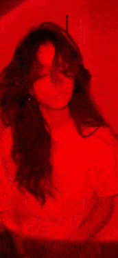 a woman with blood on her face is wearing a white shirt and holding a bloody knife .