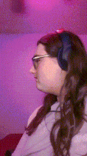 a woman wearing headphones and glasses against a pink background