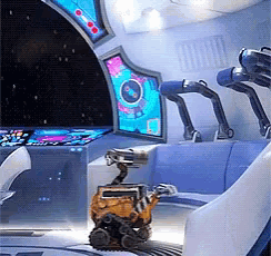 a robot is sitting in a chair in front of a computer monitor