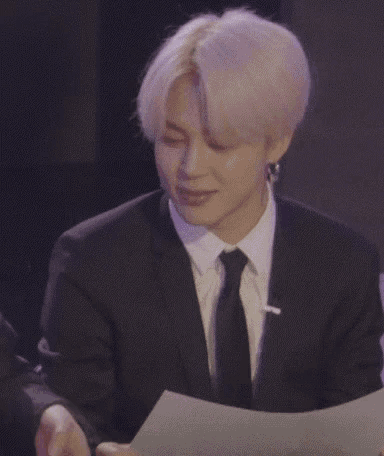 a man in a suit and tie is looking at papers