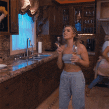 a woman in a blue dress is holding a glass of wine and asking if she has seen her phone