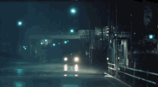 a car is driving down a street at night with a red light