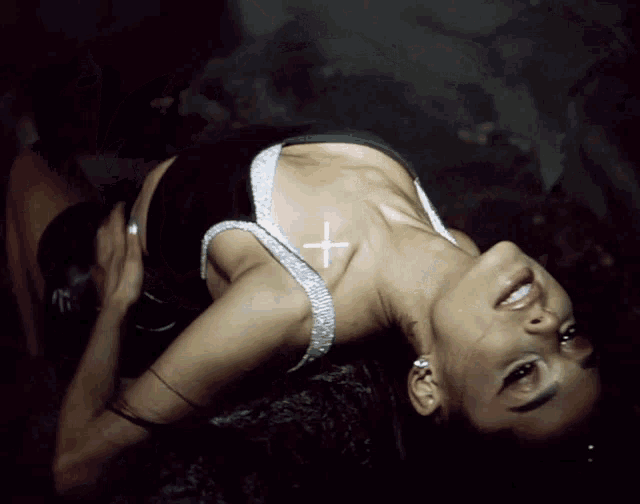 a woman with a cross on her neck is smiling