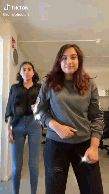 two women are dancing together in a room with a tiktok watermark on the bottom right corner .