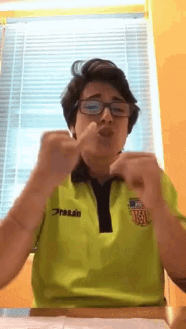 a man wearing glasses and a green shirt that says prasan
