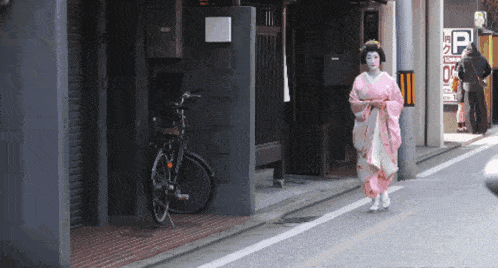 a woman in a pink kimono walks down a street in front of a sign that says parking 0